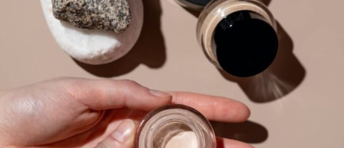 person holding clear glass bottle of concealer